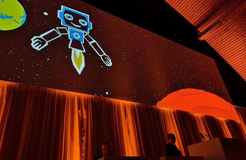 <em>Grüsse aus der Zukunft:</em> Der «Hypi-Bot» zeigte auf der Grossleinwand, wie das Bankgeschäft in 150 Jahren aussehen könnte, und stellte CEO Marianne Wildi in den Schatten. Foto: Fritz Thut <em>Grüsse aus der Zukunft:</em> Der «Hypi-Bot» zeigte auf der Grossleinwand, wie das Bankgeschäft in 150 Jahren aussehen könnte, und stellte CEO Marianne Wildi in den Schatten. Foto: Fritz Thut