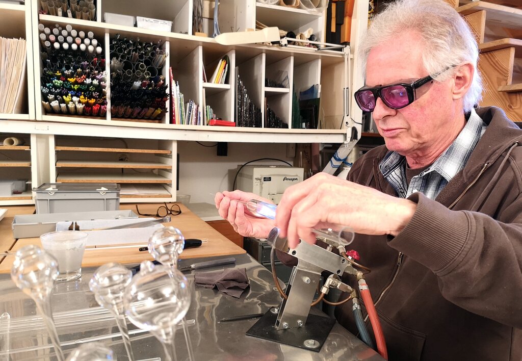 <em>Mit Schutzbrille ausgerüstet am Werken:</em> Glaskünstler Hans-Peter Eichenberger in seinem Atelier am Keltenweg. Fotos: Fritz Thut