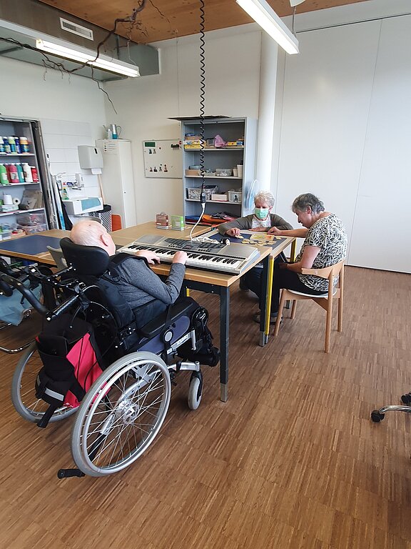 Keyboard spielen und Puzzle legen: Jeder darf tun, was geht und Freude macht – mit Begleitung von Marianne Brudermann (hinten). Foto: zvg
